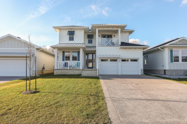Two story home with white siding and blue accents.