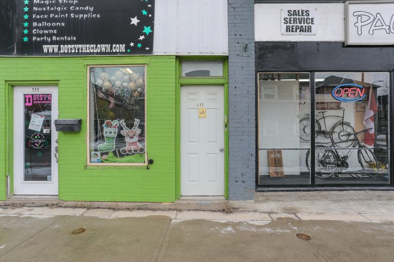 Downtown brick building with green and grey paint.