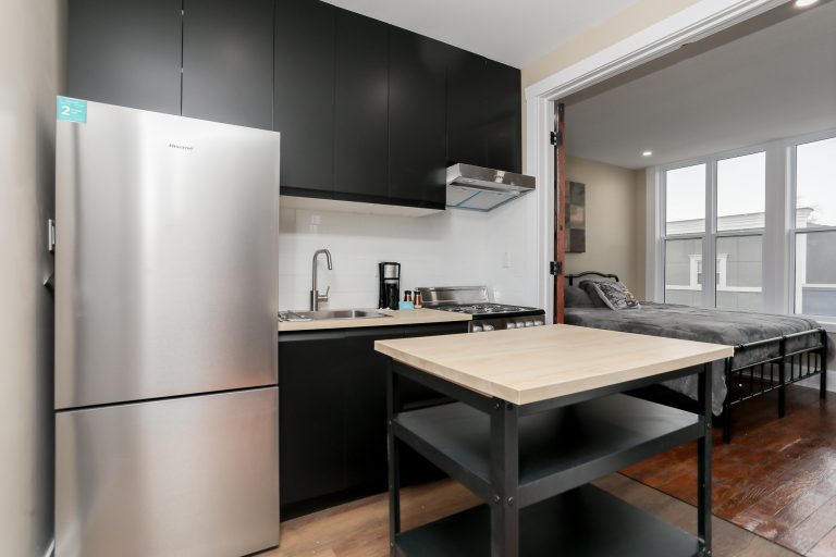 Modern kitchen with black cabinets and stainless steel appliances.