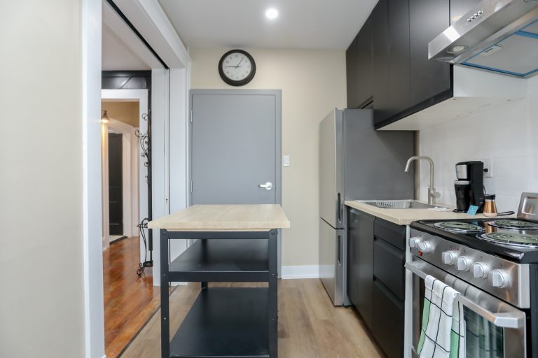 Modern kitchen with a black rolling portable kitchen island.