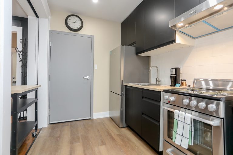 Modern kitchen with black cabinets and stainless steel appliances.