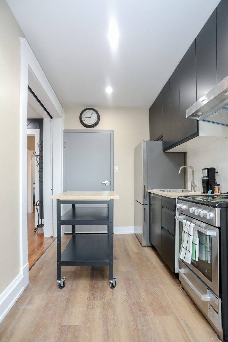 Long galley style kitchen with a rolling portable kitchen island.