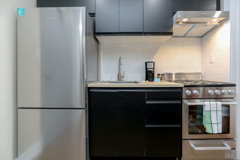 Modern new kitchen with sleek black cabinets and stainless steel appliances.