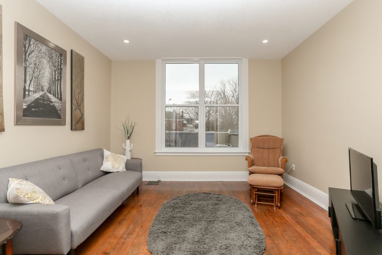 Cozy living room with natural wood and a grey love seat.
