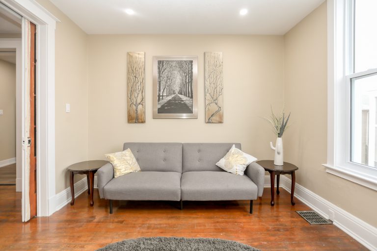 Cozy living room with natural wood and a grey love seat.
