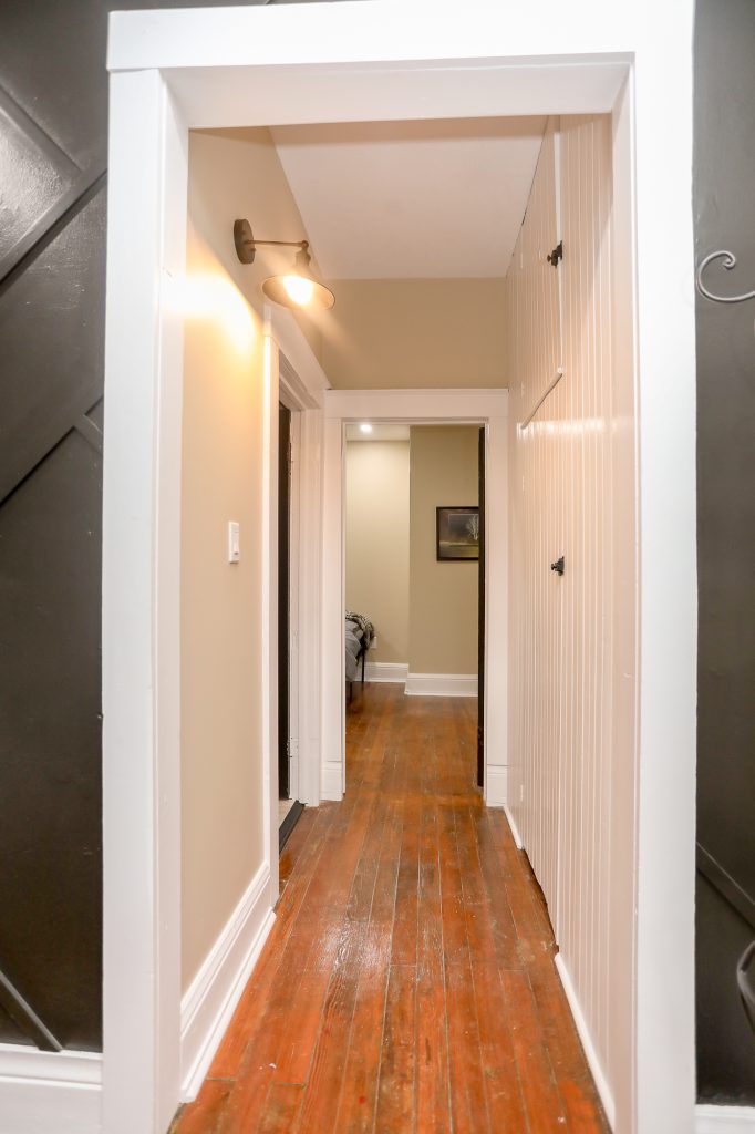 Long hallway with natural hard wood floors.