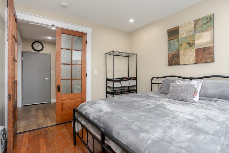 Master bedroom with plush grey bedspread.
