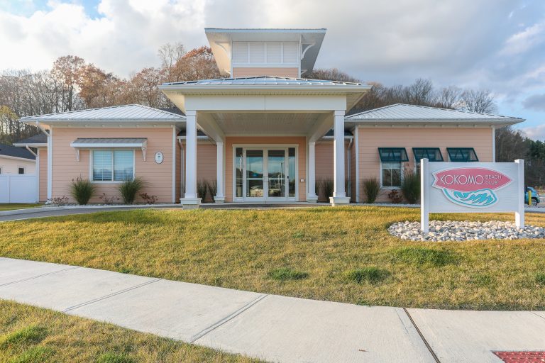 Front of Kokomo Beach Club with peach coloured siding and white accents.