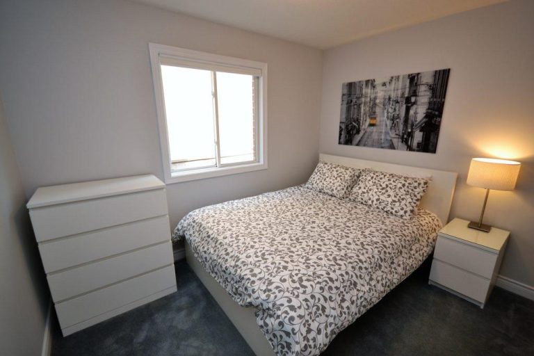 Cozy bedroom with warm lamp beside the bed.