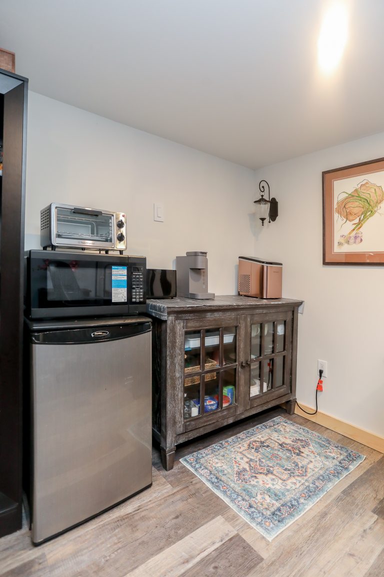 Small kitchenette in apartment with small fridge.