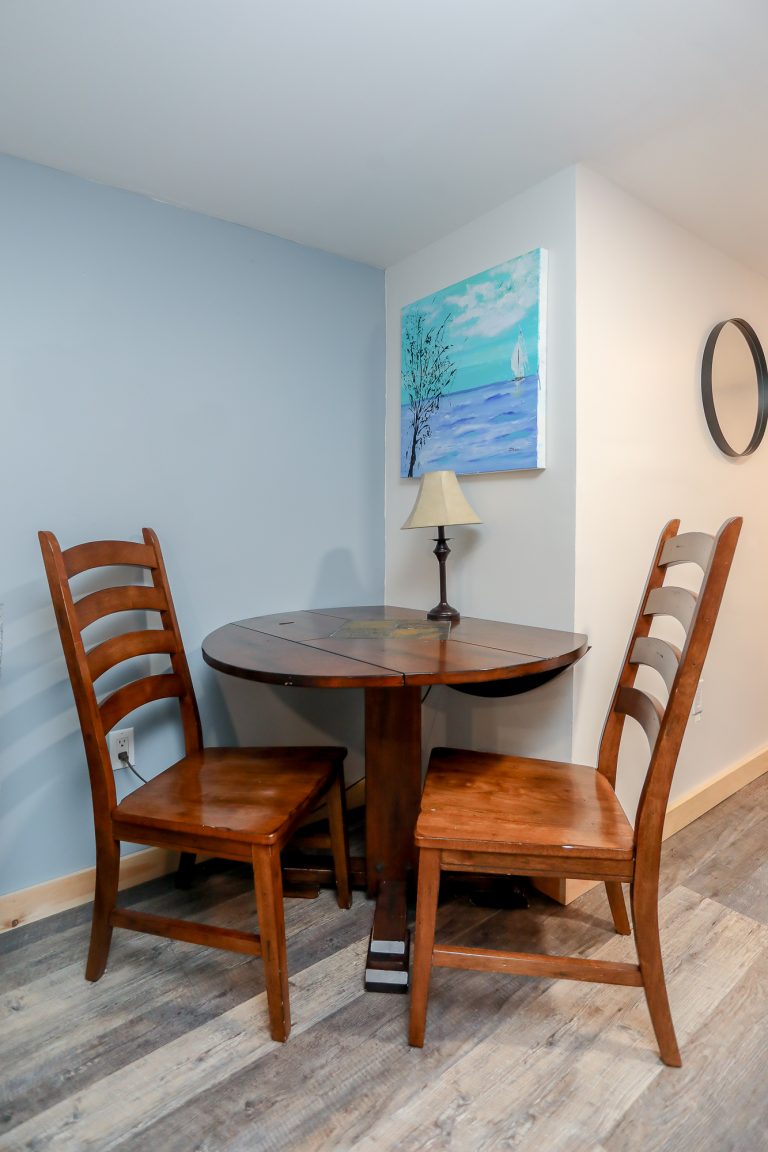 Small dining area with natural wood table and chairs.