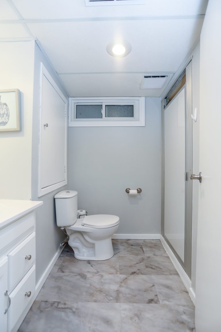 Small bathroom with marble style tiles.